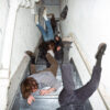 The members of the band Geese, falling down the stairs