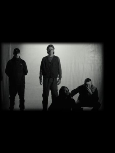 Black and white photo of four members of Folly Group