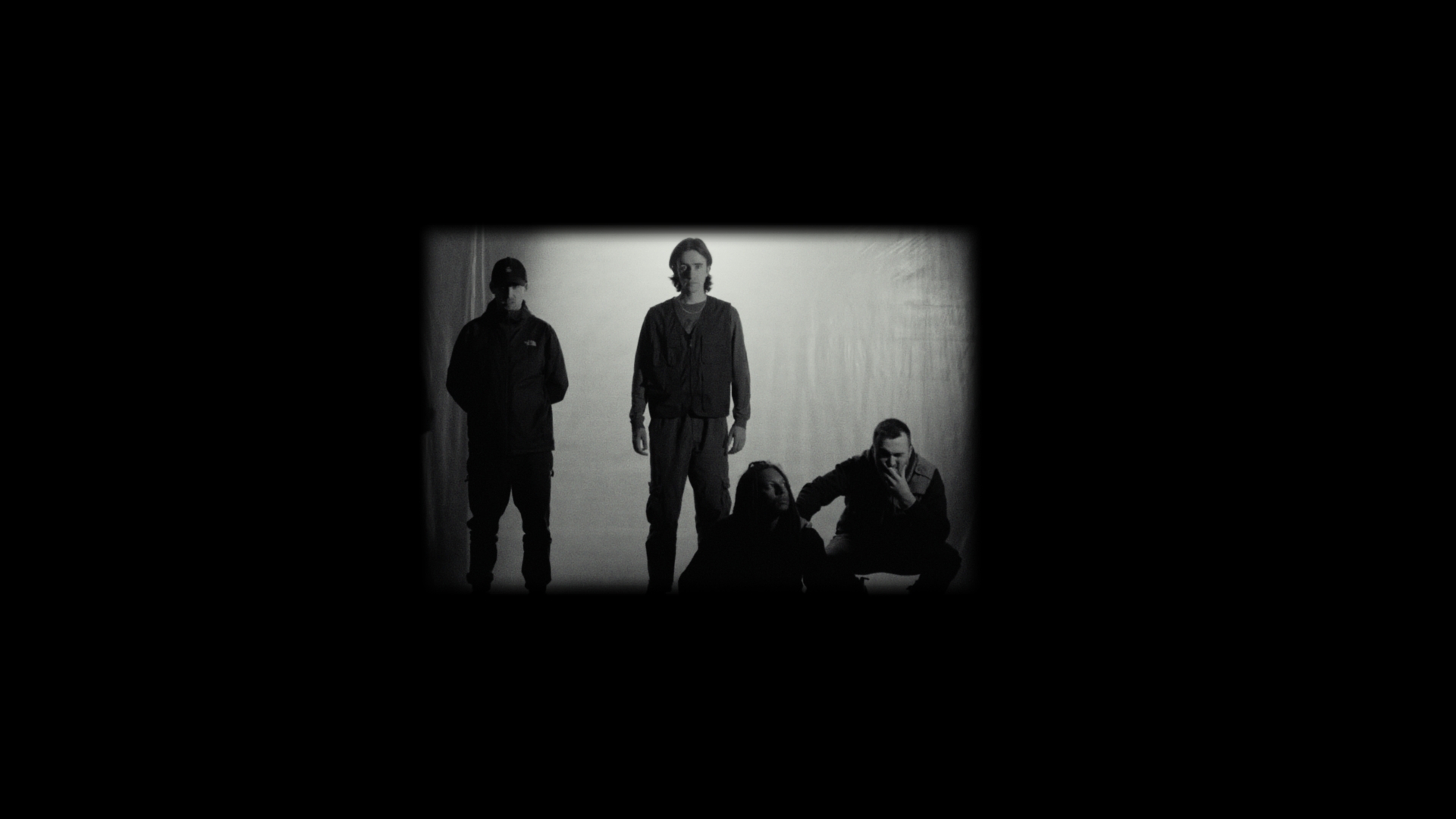 Black and white photo of four members of Folly Group