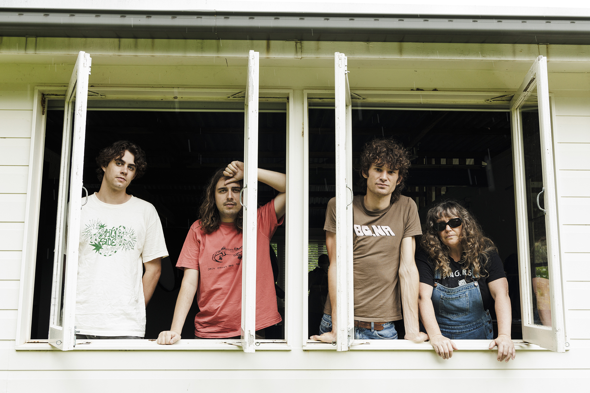 The four members of the band Girl and Girl looking out a window