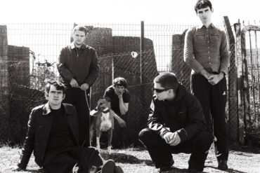 Black and white photo of the six members of the band Cardinals