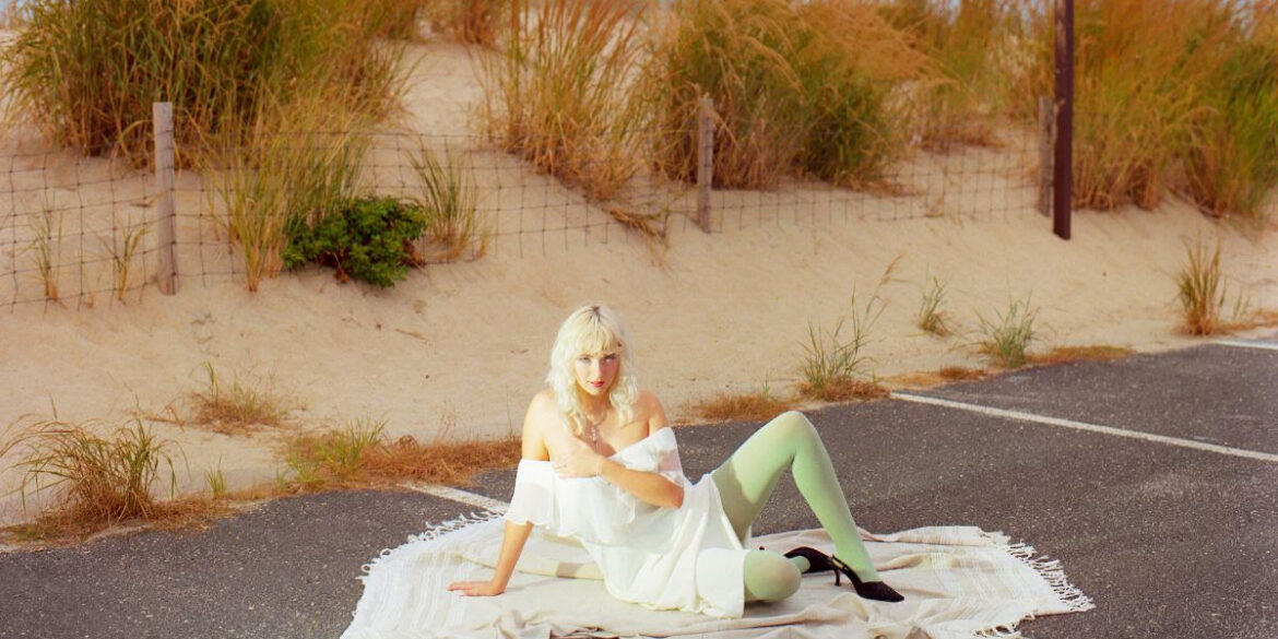 girlpuppy sitting on the floor in a car parking space by the beach